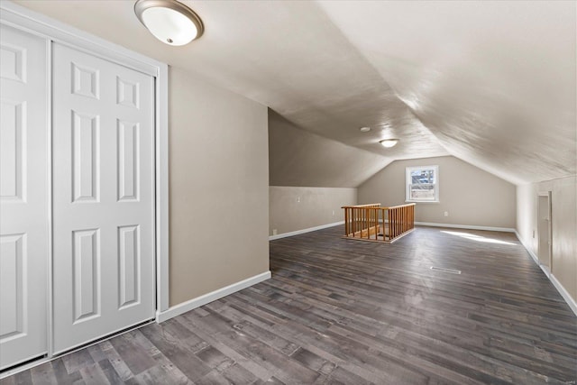 bonus room with lofted ceiling and dark hardwood / wood-style flooring