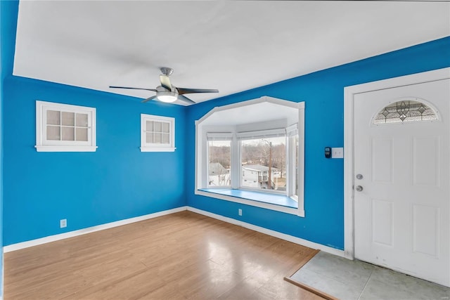 foyer entrance with ceiling fan and light wood-type flooring