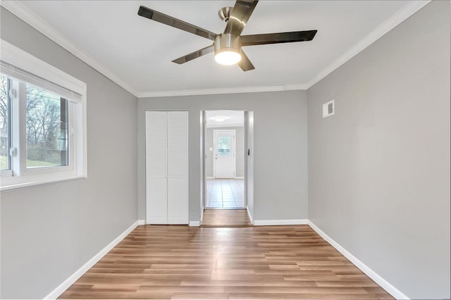 unfurnished bedroom featuring light hardwood / wood-style floors, a closet, crown molding, and ceiling fan