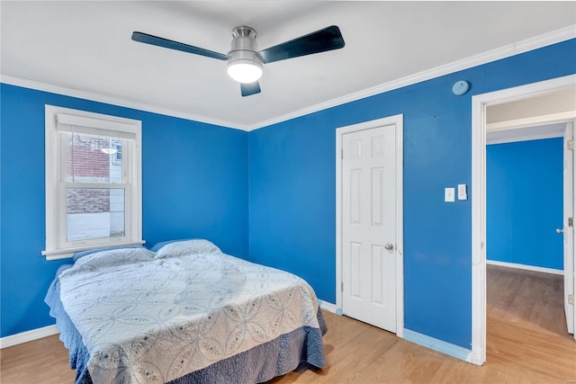 bedroom with light hardwood / wood-style flooring, ceiling fan, and ornamental molding