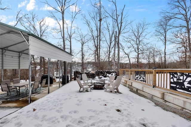 snowy yard with a wooden deck and a fire pit