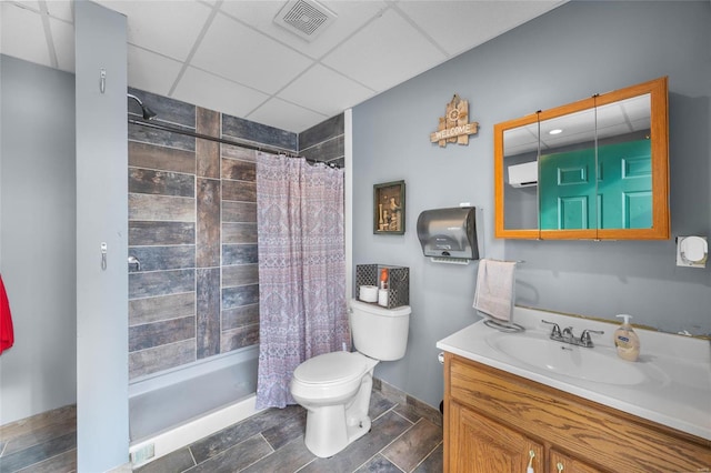 bathroom featuring toilet, vanity, a shower with curtain, and a drop ceiling