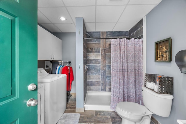 bathroom featuring toilet, a paneled ceiling, a shower with curtain, and washer / clothes dryer