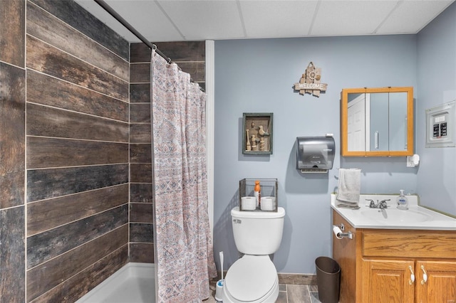 bathroom with toilet, a shower with curtain, a drop ceiling, and vanity