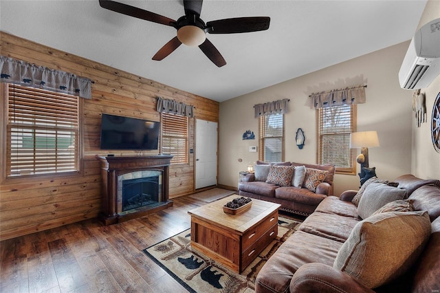 living room featuring ceiling fan, hardwood / wood-style floors, wooden walls, and a wall mounted air conditioner