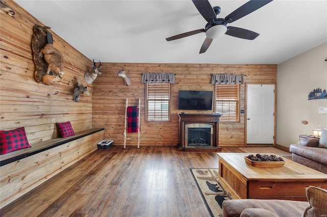 unfurnished living room with ceiling fan, dark hardwood / wood-style flooring, and wood walls