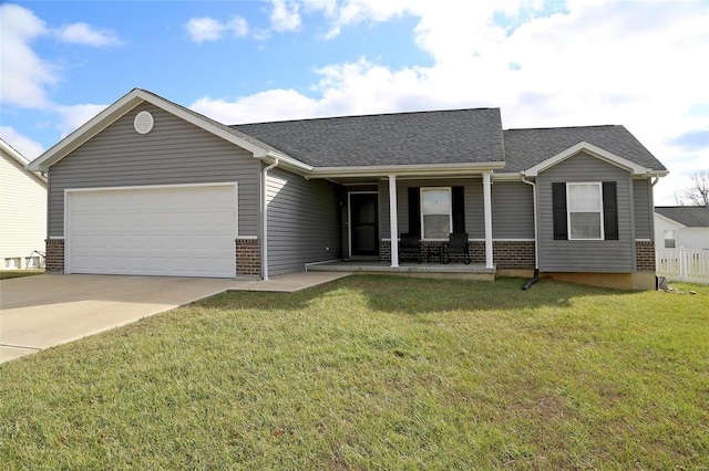 view of front of home featuring covered porch, a garage, and a front yard