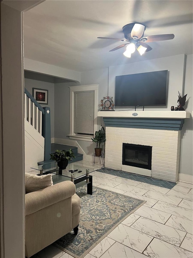 living room featuring ceiling fan and a fireplace