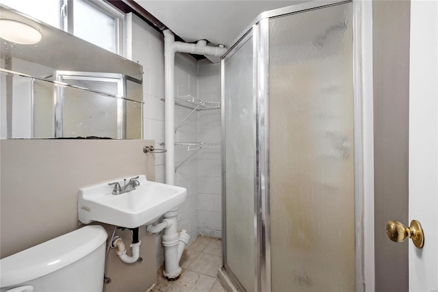 bathroom featuring toilet, sink, tile patterned flooring, and walk in shower