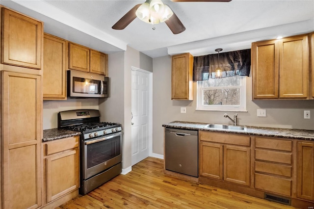 kitchen featuring pendant lighting, sink, ceiling fan, light hardwood / wood-style floors, and stainless steel appliances