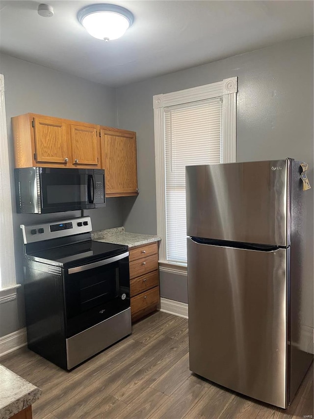 kitchen with appliances with stainless steel finishes and dark hardwood / wood-style flooring