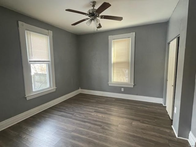 empty room with dark wood-type flooring and ceiling fan