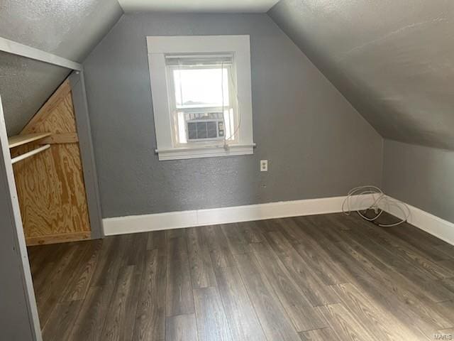 additional living space featuring dark hardwood / wood-style floors and lofted ceiling