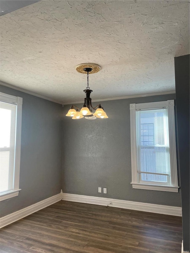 spare room featuring crown molding, dark wood-type flooring, a textured ceiling, and a notable chandelier