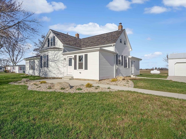 view of side of property featuring a lawn and an outbuilding