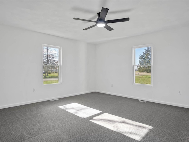 unfurnished room featuring dark colored carpet and ceiling fan