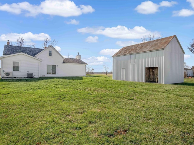 view of yard with ac unit, an outbuilding, and central air condition unit