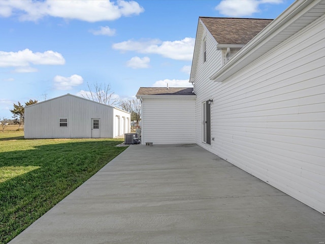 view of side of property with central AC unit, a patio area, and a lawn