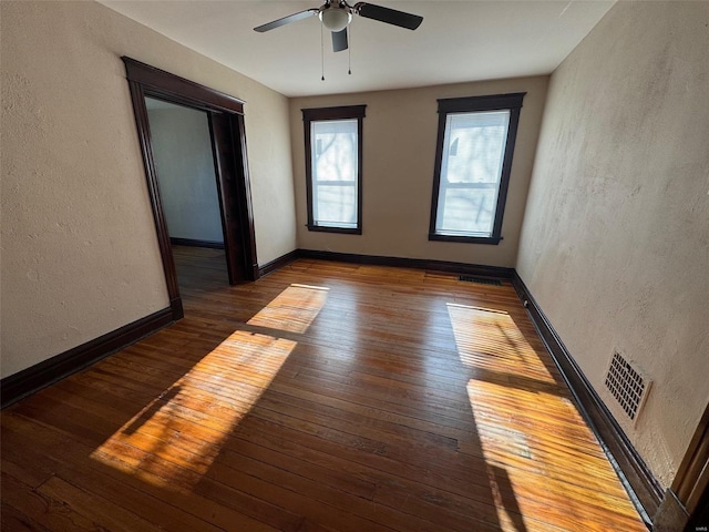 spare room featuring ceiling fan and dark wood-type flooring