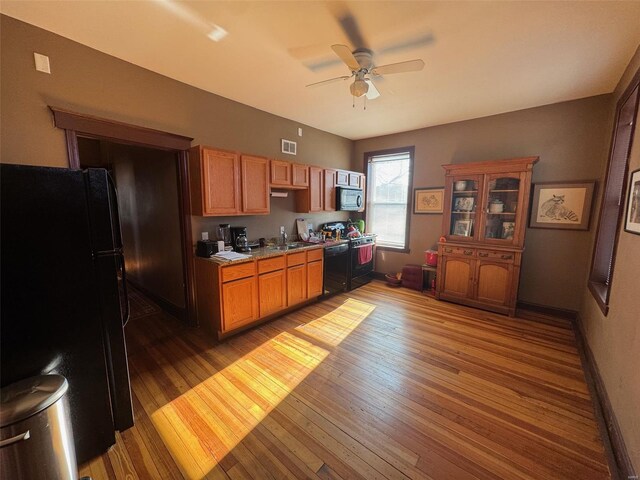 kitchen with ceiling fan, hardwood / wood-style floors, black appliances, and sink