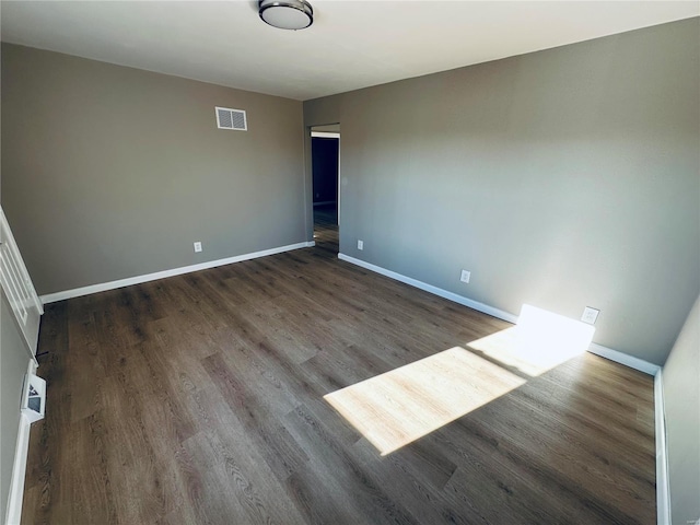 empty room with dark hardwood / wood-style flooring