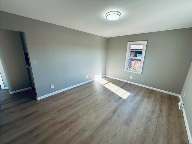 empty room with dark hardwood / wood-style flooring