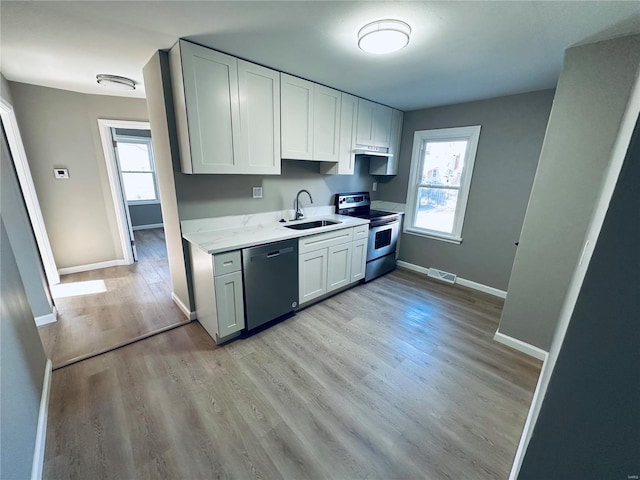 kitchen featuring stainless steel electric stove, dishwasher, white cabinetry, light hardwood / wood-style floors, and sink