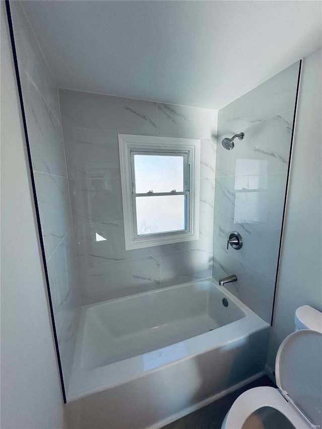 bathroom featuring toilet and tiled shower / bath combo