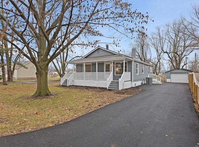 view of front of home featuring an outbuilding, a porch, a garage, and a front lawn