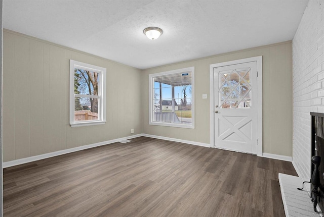 unfurnished living room featuring a fireplace, hardwood / wood-style floors, and a textured ceiling