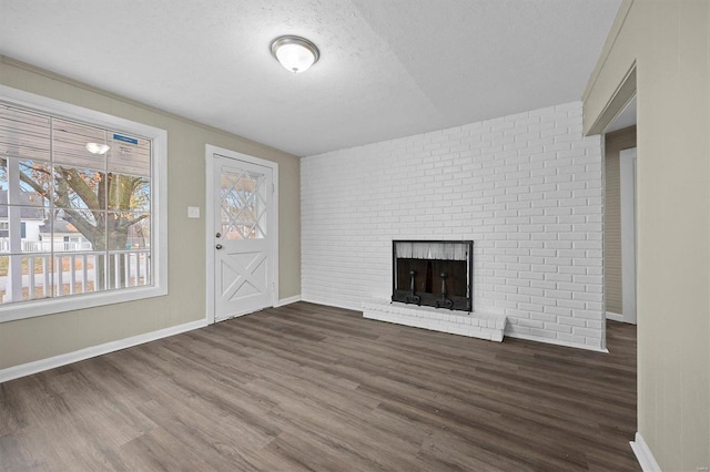 unfurnished living room featuring a textured ceiling, dark hardwood / wood-style flooring, and a fireplace