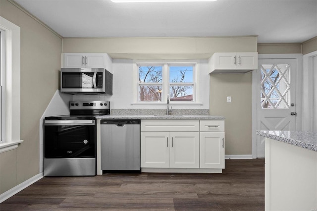 kitchen featuring white cabinets, appliances with stainless steel finishes, light stone counters, and sink