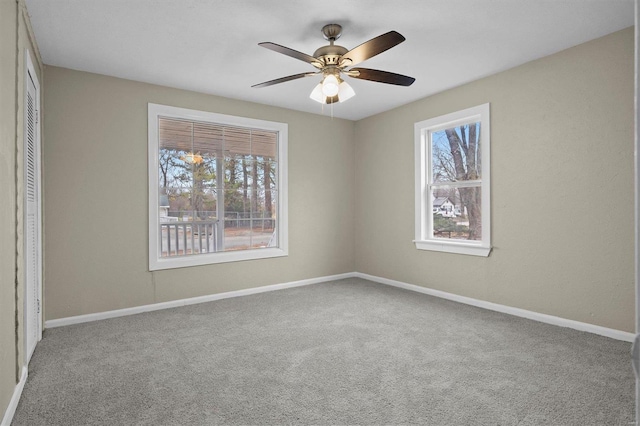 carpeted empty room featuring plenty of natural light and ceiling fan