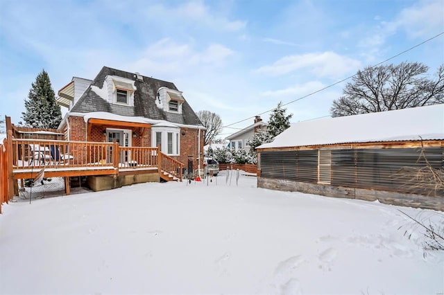 snow covered house featuring a wooden deck