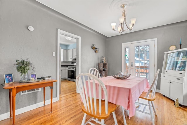 dining space with a chandelier and light hardwood / wood-style floors