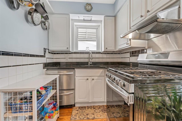 kitchen featuring white cabinets, stainless steel appliances, tasteful backsplash, and sink