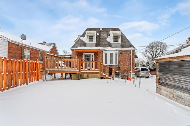 snow covered rear of property featuring a wooden deck