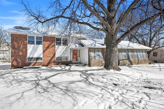 tri-level home featuring brick siding