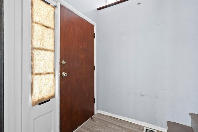 doorway to outside with visible vents, baseboards, and wood finished floors