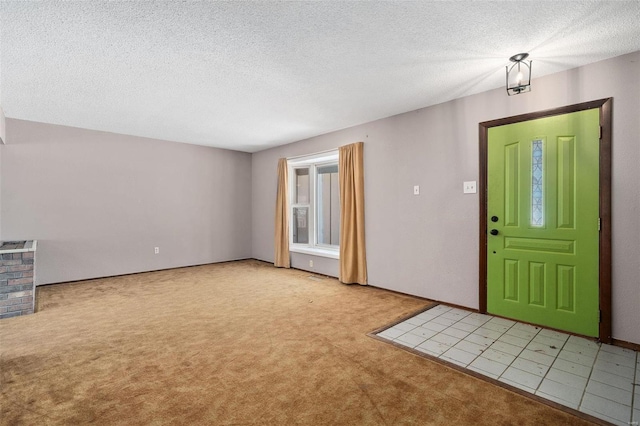 entrance foyer featuring a textured ceiling and light colored carpet