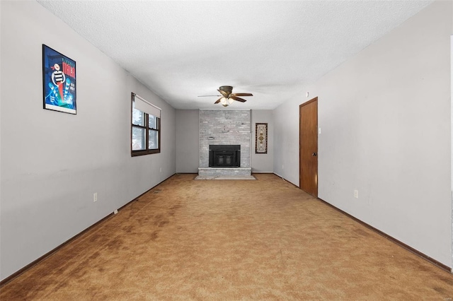 unfurnished living room featuring baseboards, a ceiling fan, light colored carpet, a textured ceiling, and a fireplace