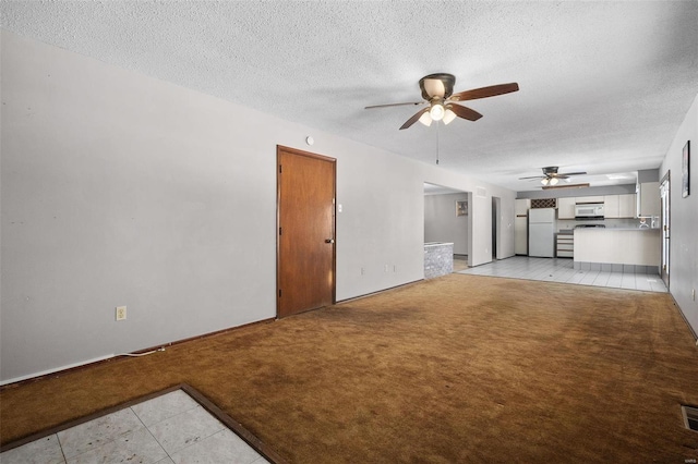 unfurnished living room with light carpet, ceiling fan, visible vents, and a textured ceiling