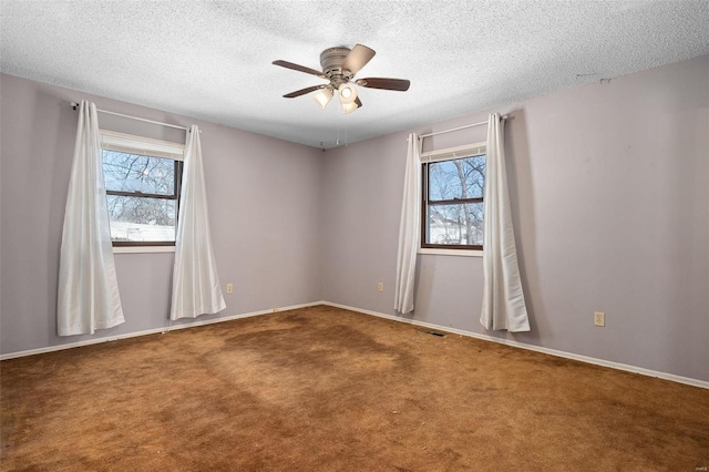 empty room with ceiling fan, carpet, visible vents, and baseboards