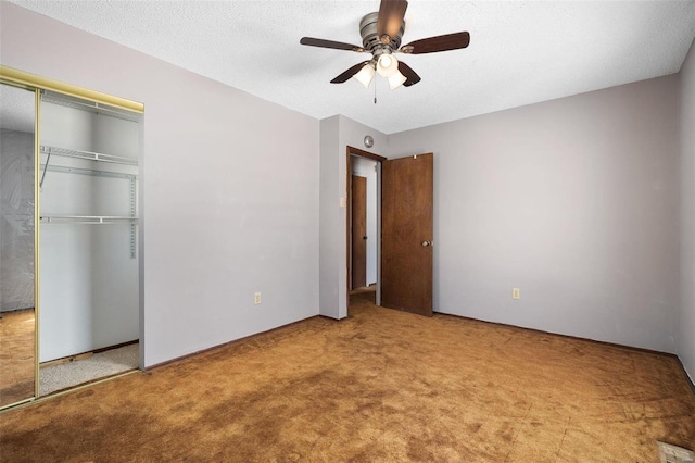 unfurnished bedroom with a closet, carpet flooring, ceiling fan, and a textured ceiling