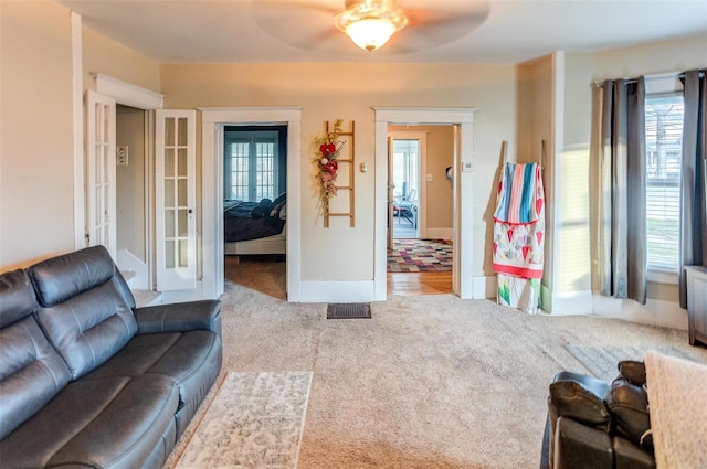 living room with light colored carpet and ceiling fan