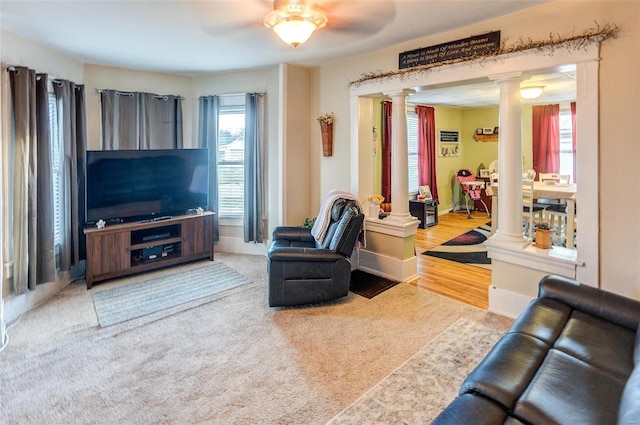 living room featuring carpet flooring, ornate columns, and ceiling fan