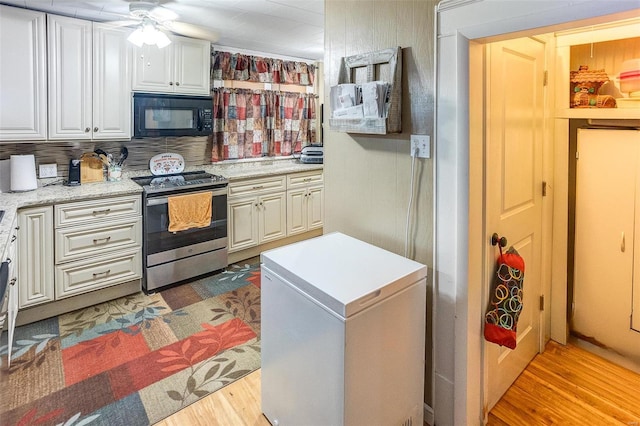 kitchen featuring white cabinets, stainless steel range with electric cooktop, light hardwood / wood-style floors, and fridge