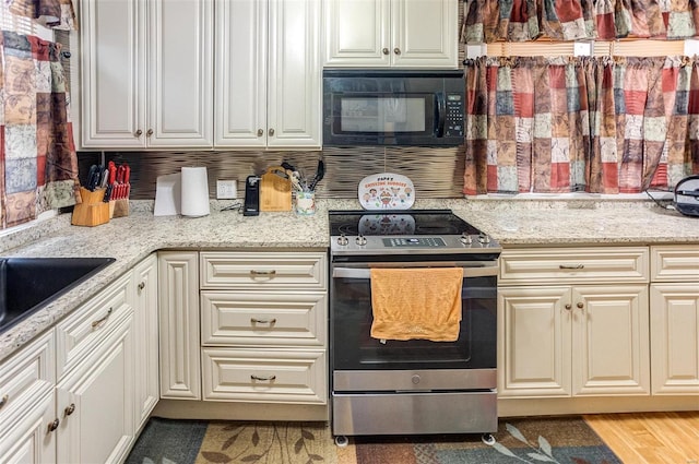 kitchen featuring light stone counters and stainless steel electric range