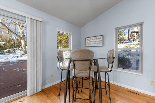 dining space with hardwood / wood-style flooring and lofted ceiling