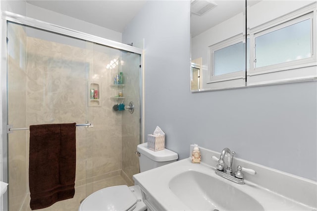 bathroom featuring toilet, sink, and a shower with shower door